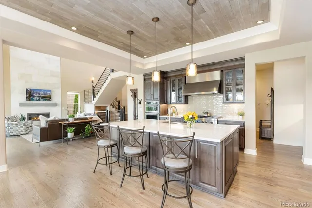 a kitchen with stainless steel appliances kitchen island granite countertop a table chairs and a refrigerator