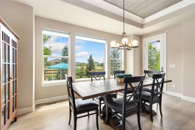 a dining room with furniture a chandelier and wooden floor