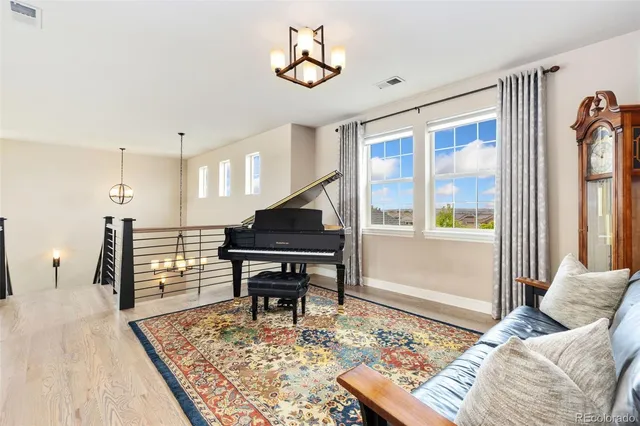 a living room with furniture and a piano table