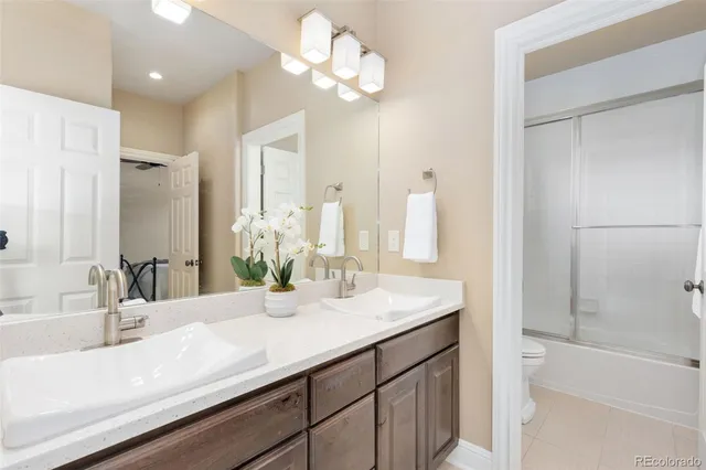 a bathroom with a sink double vanity granite tub and a mirror