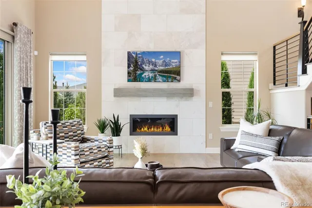 a living room with furniture a fireplace and a large window