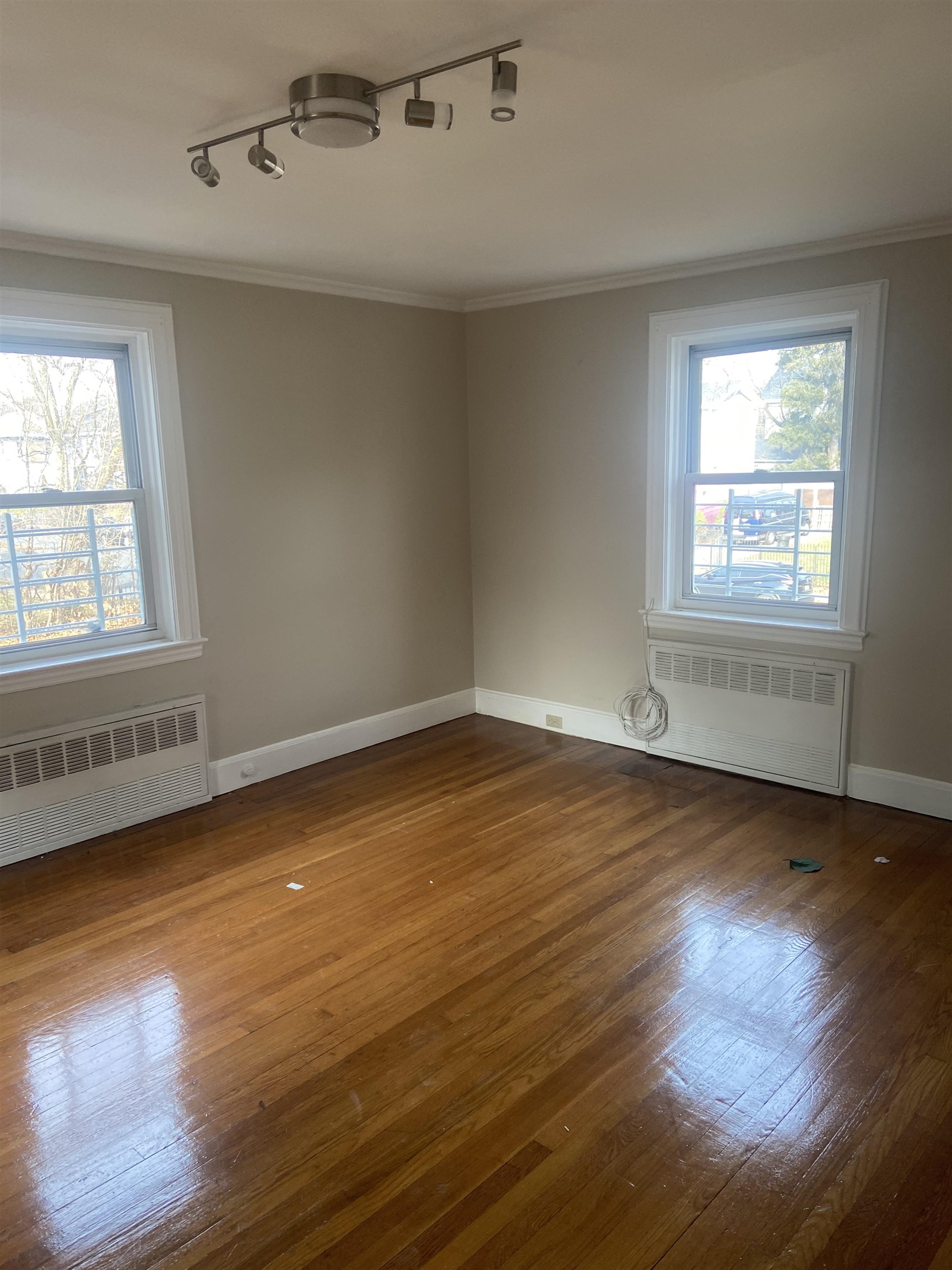 725 Elizabeth Avenue Newark, NJ 07112 - Photo 2 of 7 an empty room with wooden floor and windows