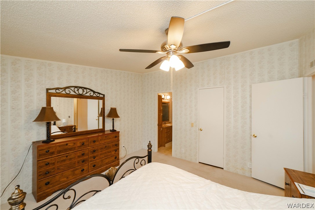 3003 Hualapai Mountain Road Kingman, AZ 86401 - Photo 19 of 49 a bedroom with a bed and a chandelier