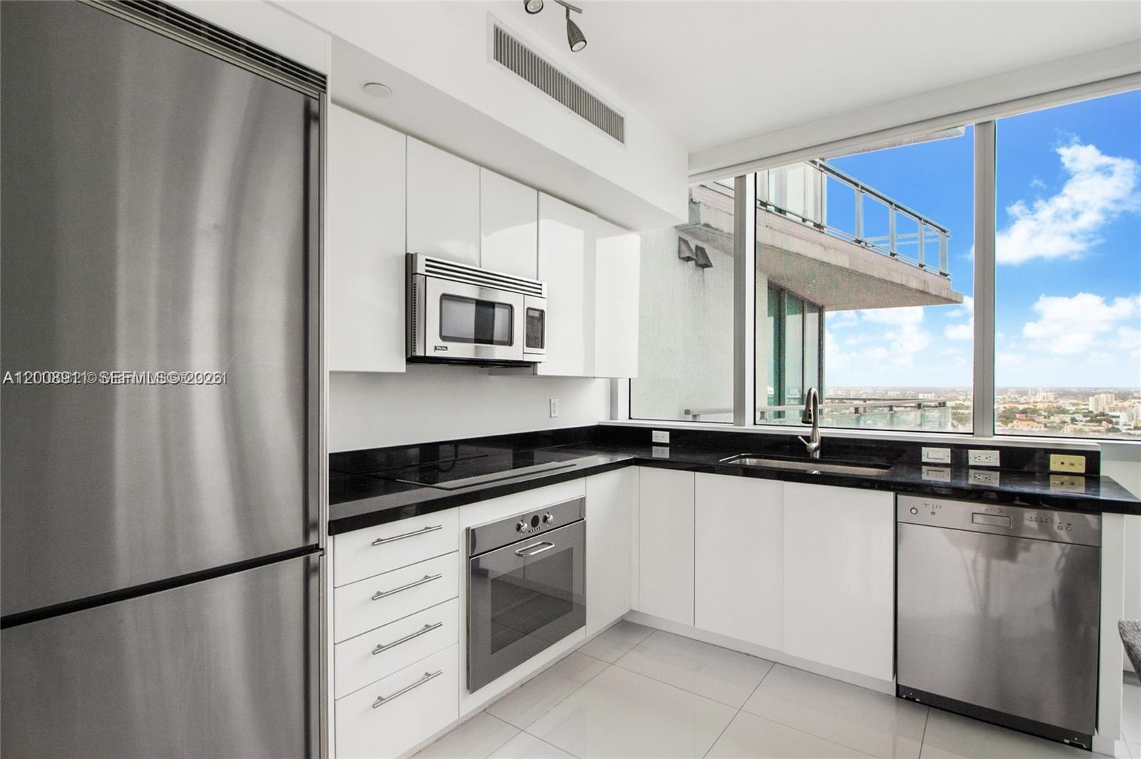 92 Southwest 3rd Street, Unit 2510 Miami, FL 33130 - Photo 4 of 35 a kitchen with white cabinets sink and appliances
