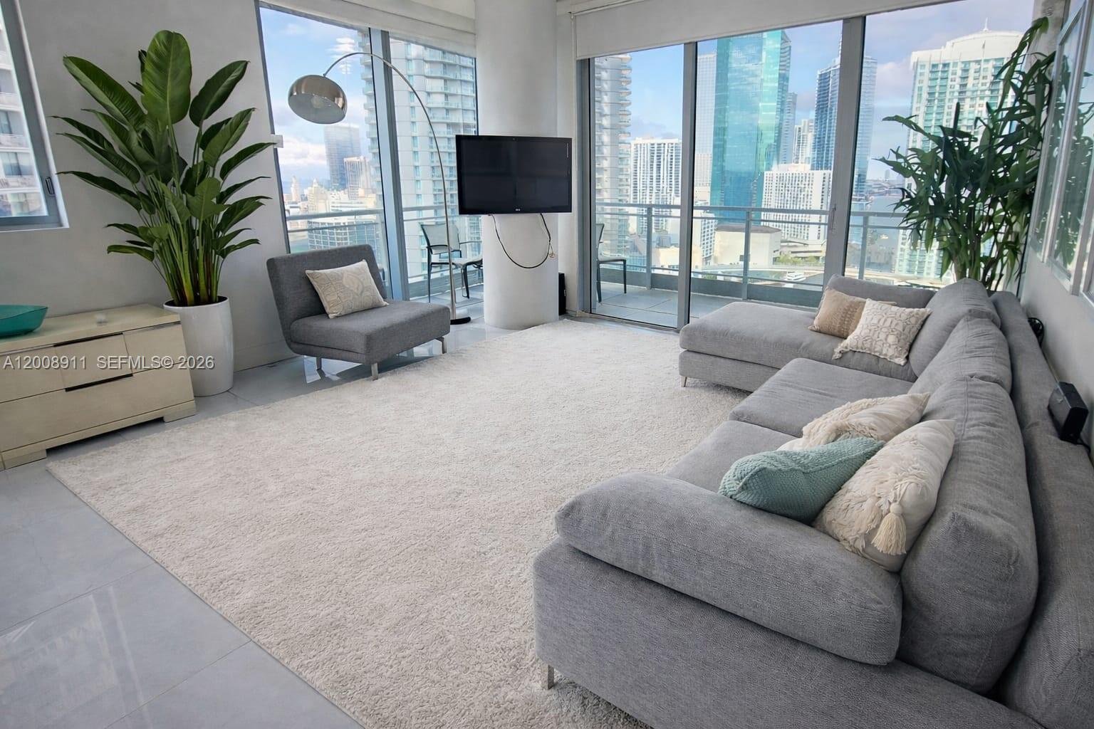 92 Southwest 3rd Street, Unit 2510 Miami, FL 33130 - Photo 5 of 35 a living room with furniture and a flat screen tv