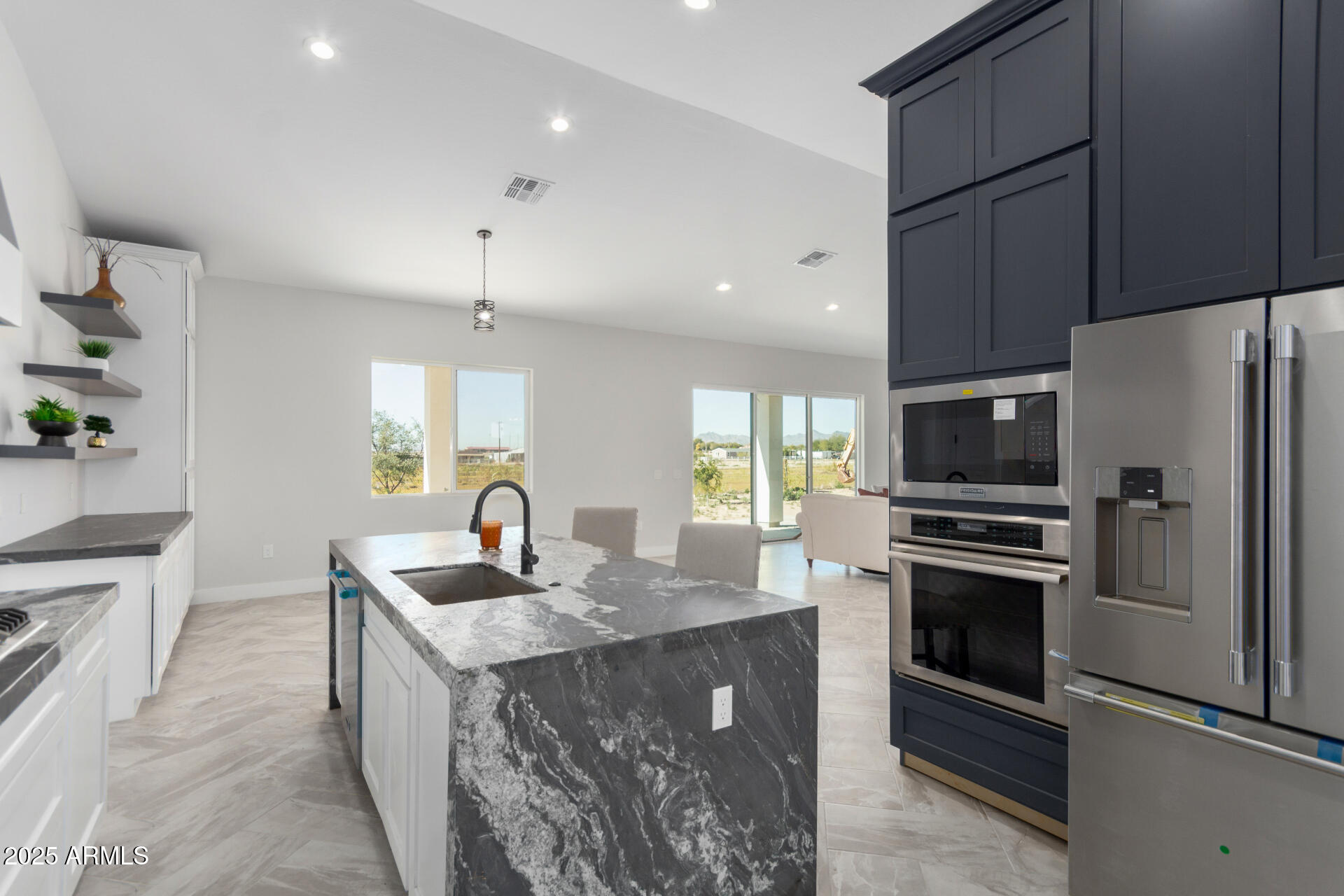 19657 West Dunlap Road Buckeye, AZ 85326 - Photo 19 of 45 a kitchen with kitchen island granite countertop a sink a counter top space appliances and cabinets