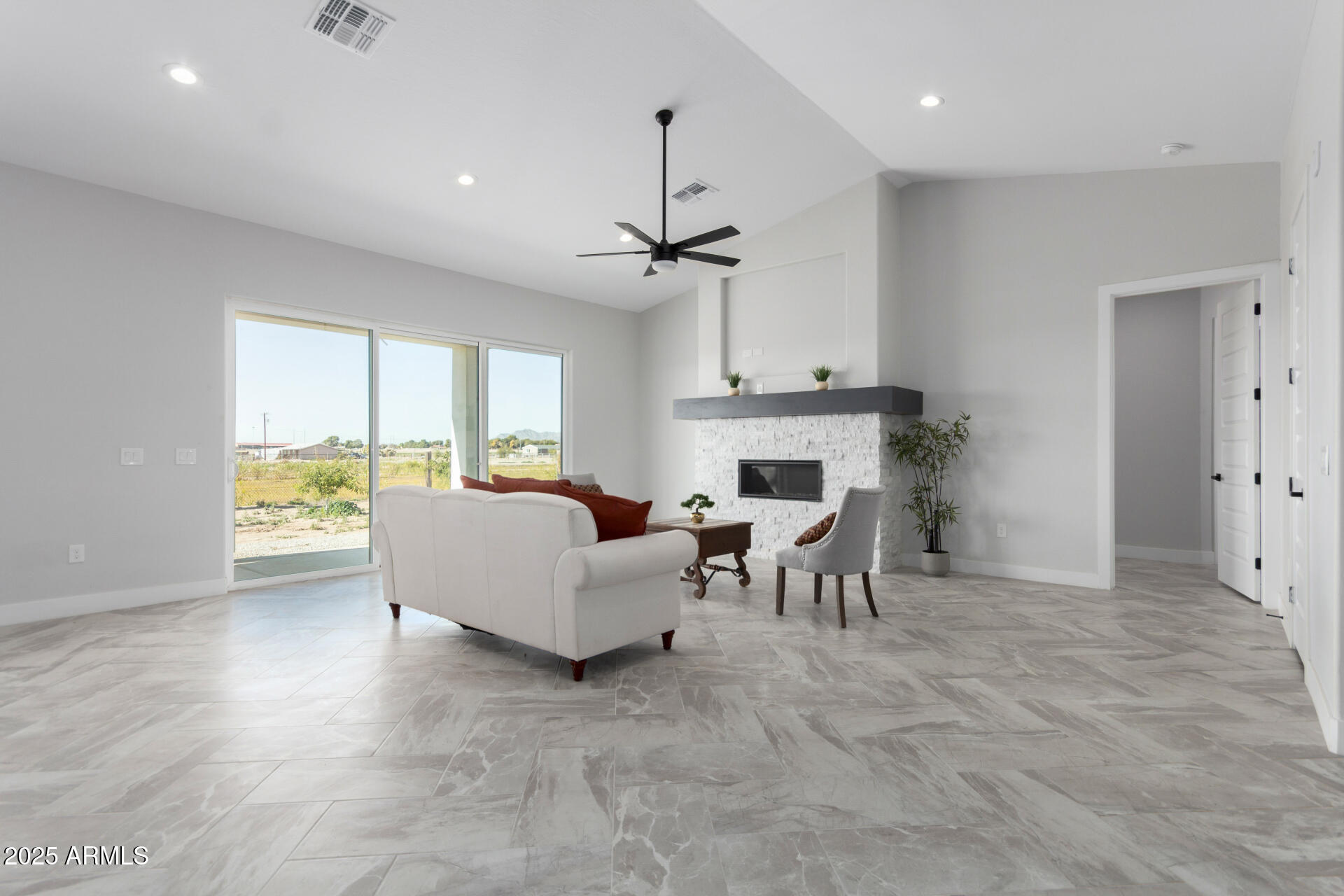 19657 West Dunlap Road Buckeye, AZ 85326 - Photo 10 of 45 a living room with furniture a fireplace and a chandelier