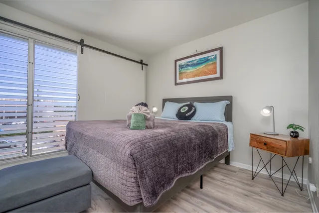 a bedroom with a bed and wooden floor