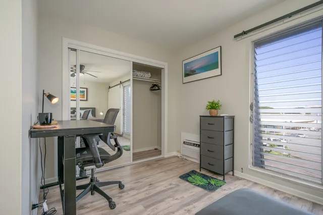 a view of a workspace with furniture and a window