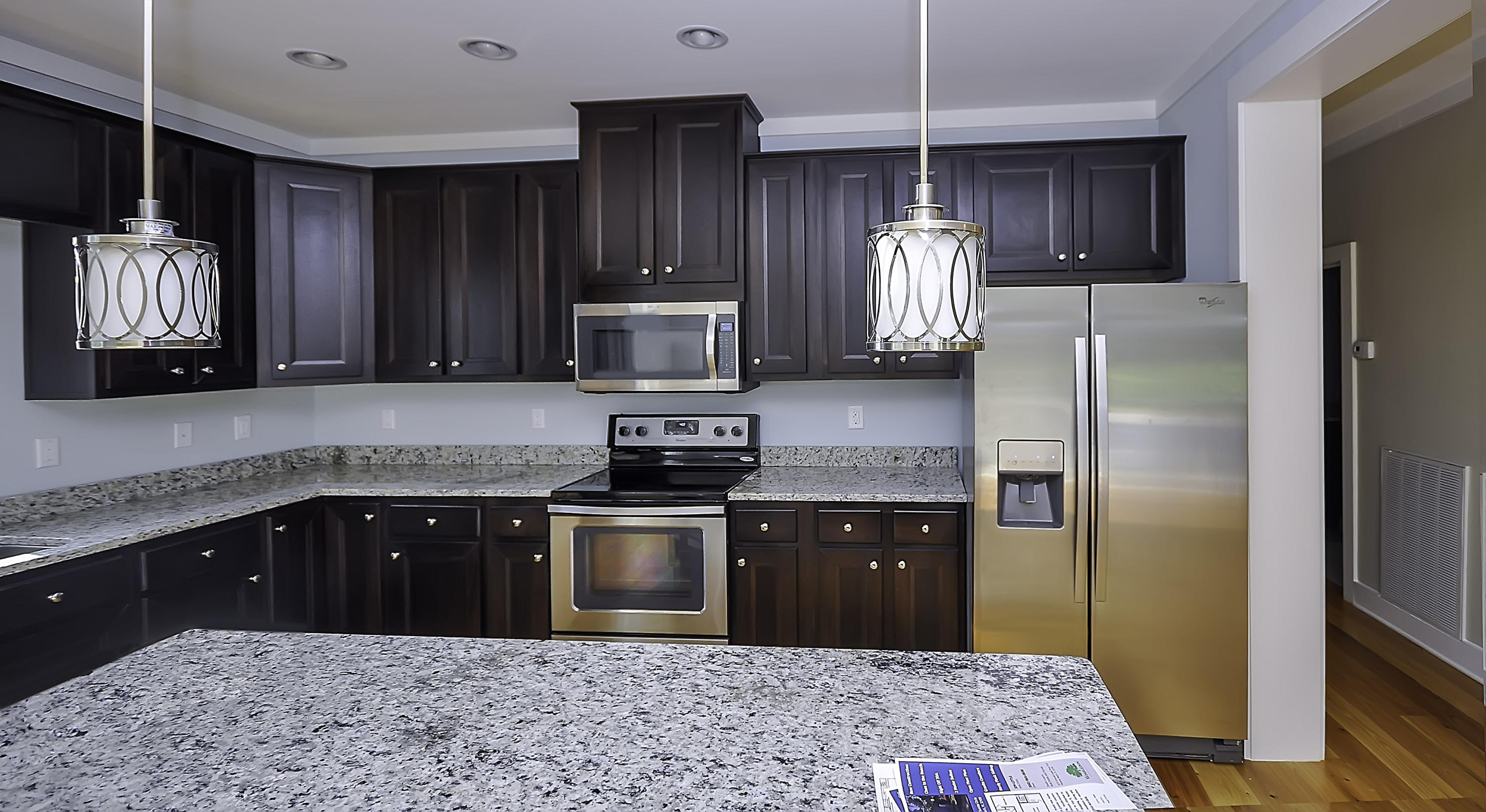 55 Sunrise Circle Santa Rosa Beach, FL 32459 - Photo 3 of 8 a kitchen with granite countertop wooden cabinets a refrigerator and a sink