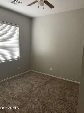 an empty room with a window and a fan