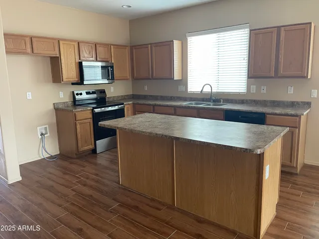 a kitchen with granite countertop a sink and steel appliances