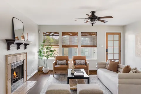 a living room with furniture fireplace and a large window