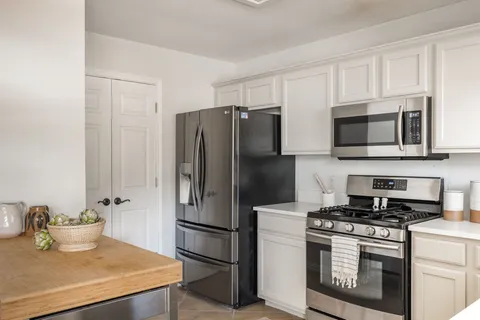 a kitchen with stainless steel appliances a sink stove refrigerator and cabinets