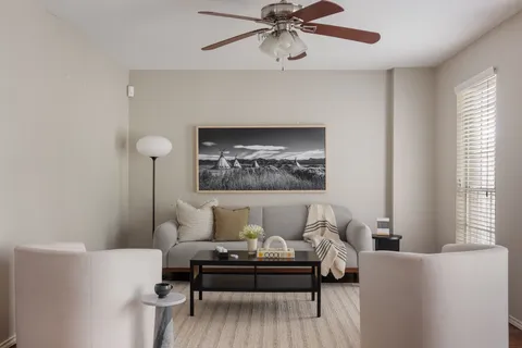 a living room with furniture and a wall painting