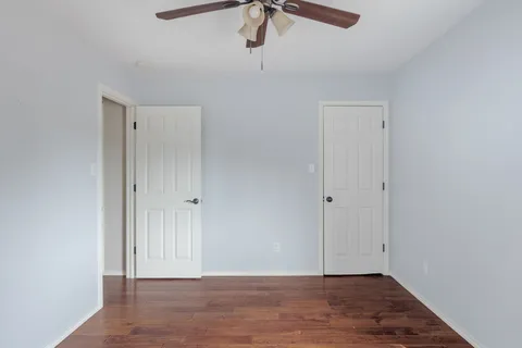 an empty room with a window and a fan