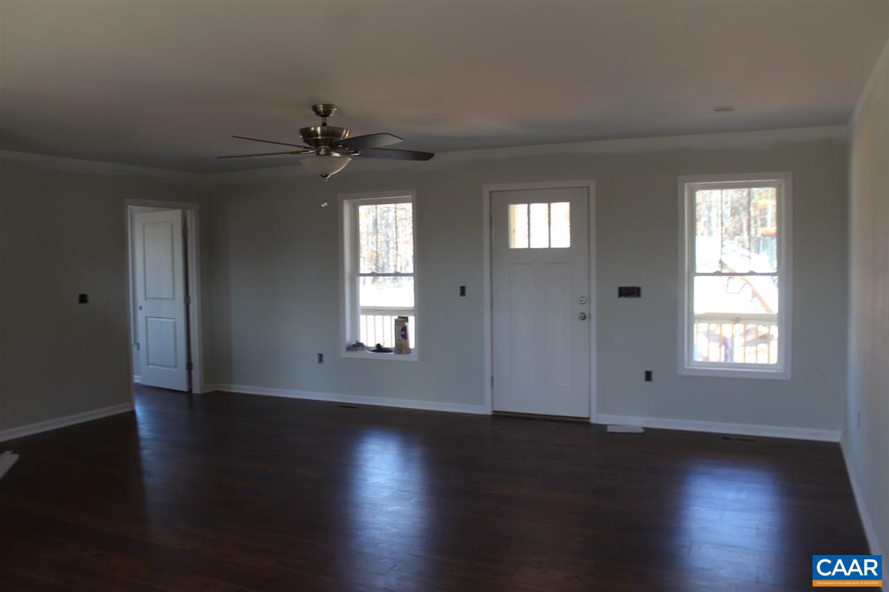 703 Correctional Center Road Dillwyn, VA 23936 - Photo 8 of 13 an empty room with wooden floor chandelier fan and windows
