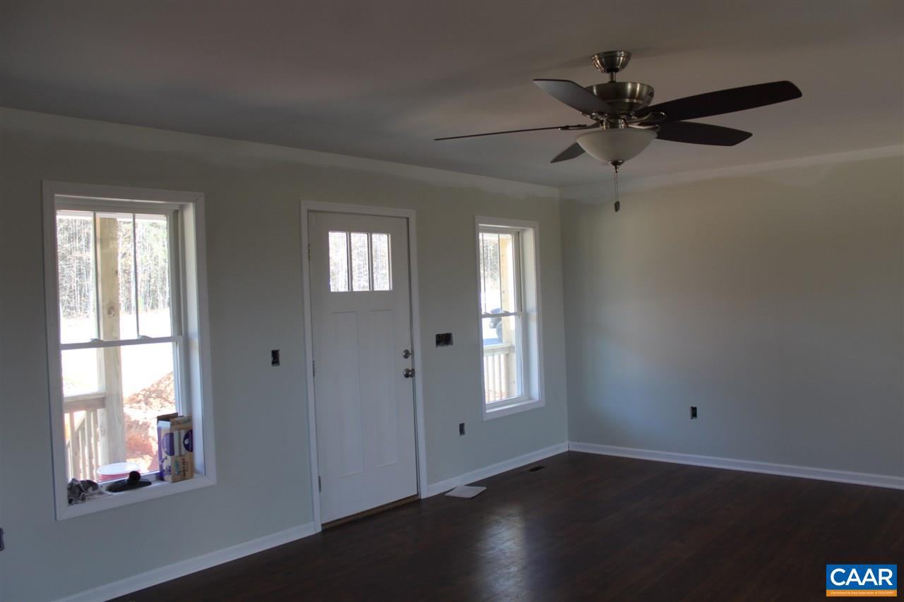 703 Correctional Center Road Dillwyn, VA 23936 - Photo 9 of 13 an empty room with wooden floor fan and windows