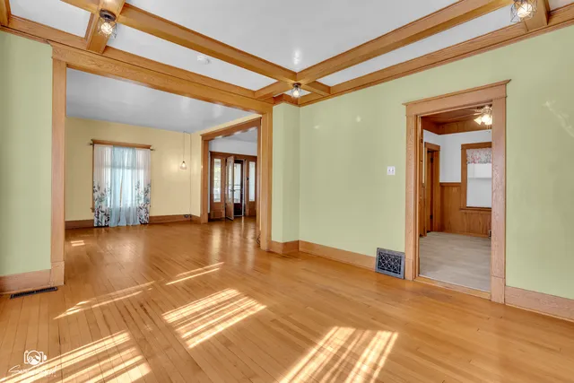 a view of an empty room with a chandelier fan