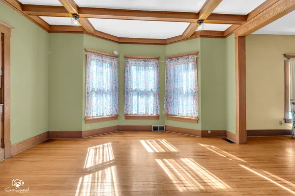 an empty room with window and chandelier fan