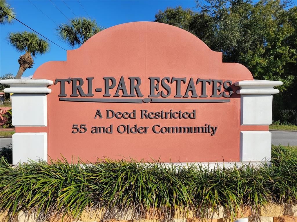 4775 Tri Par Drive Sarasota, FL 34234 - Photo 2 of 50 a sign that is sitting on a brick wall