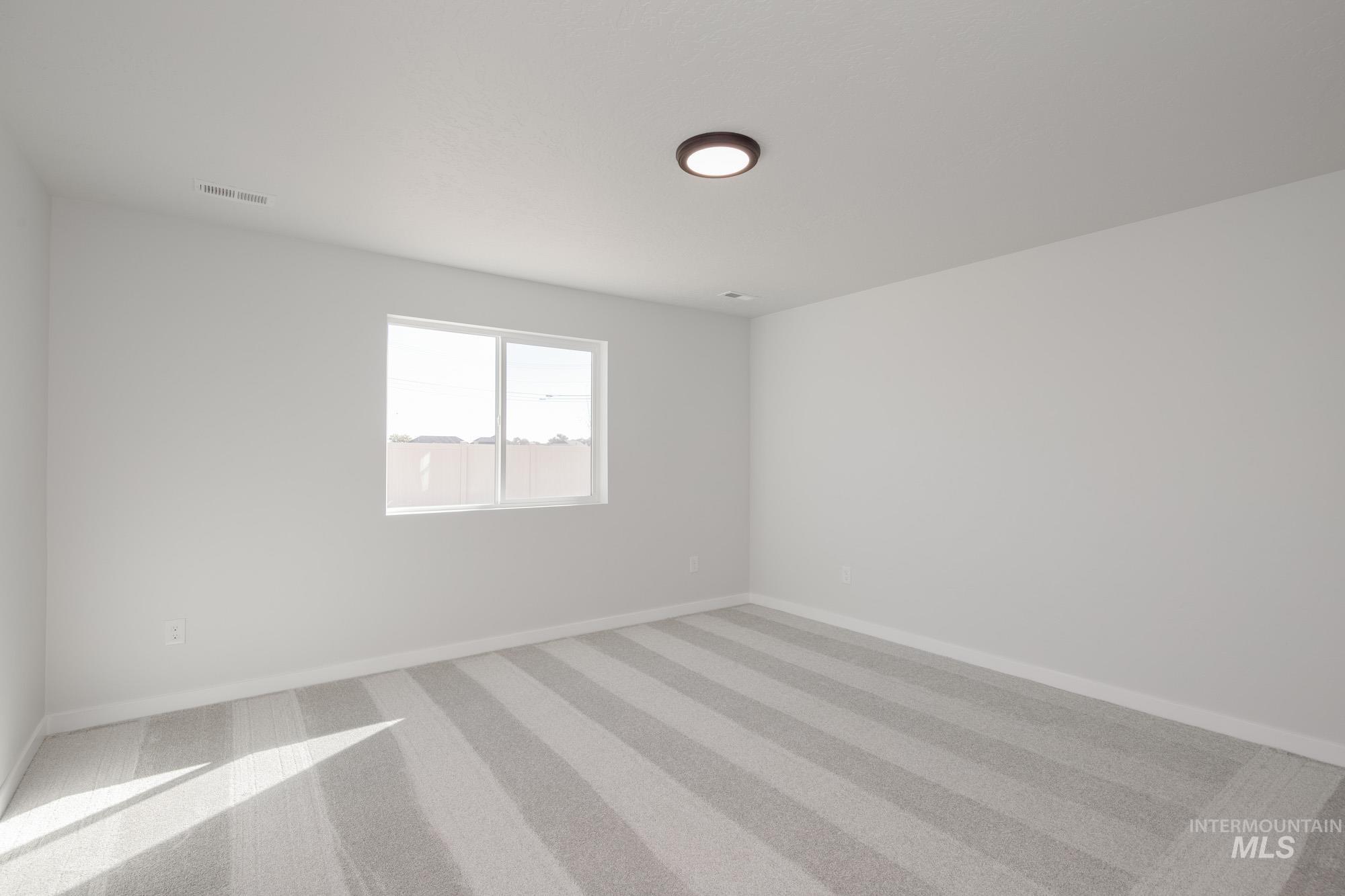 14092 Shiny Spruce Street Caldwell, ID 83607 - Photo 19 of 22 Spacious interior room with light-toned striped carpet and a single window