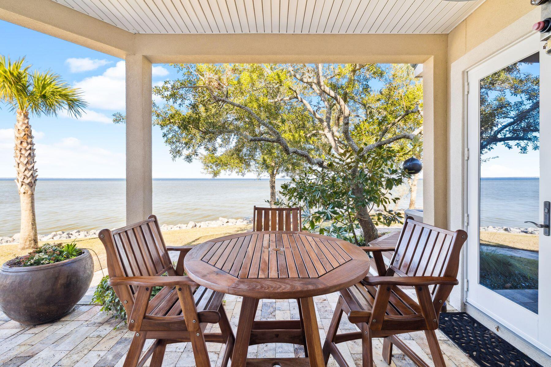 221 Bay Cir Drive Santa Rosa Beach, FL 32459 - Photo 72 of 98 a view of a balcony with table and chairs and wooden floor