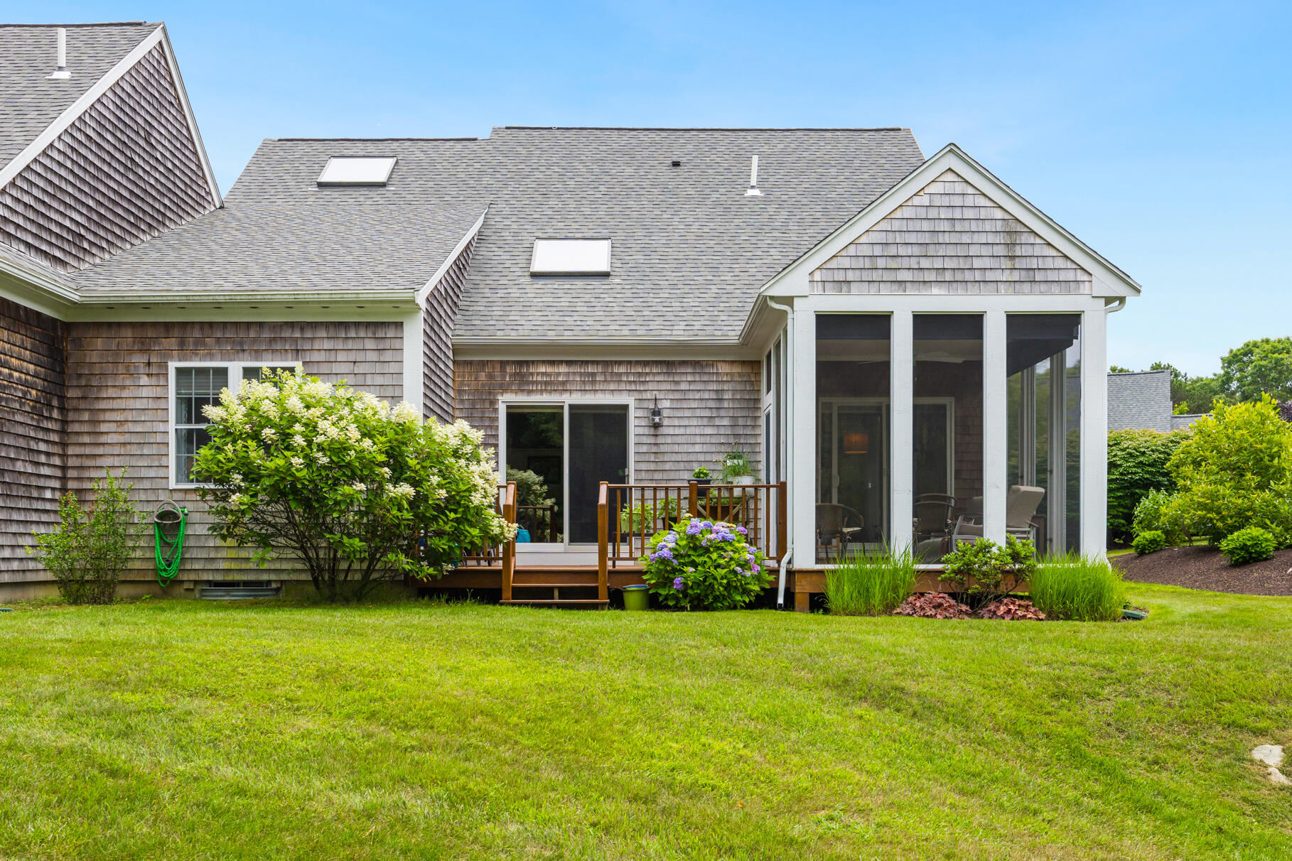 9 Stratford Ridge Mashpee, MA 02649 - Photo 4 of 34 a front view of a house with a garden and plants