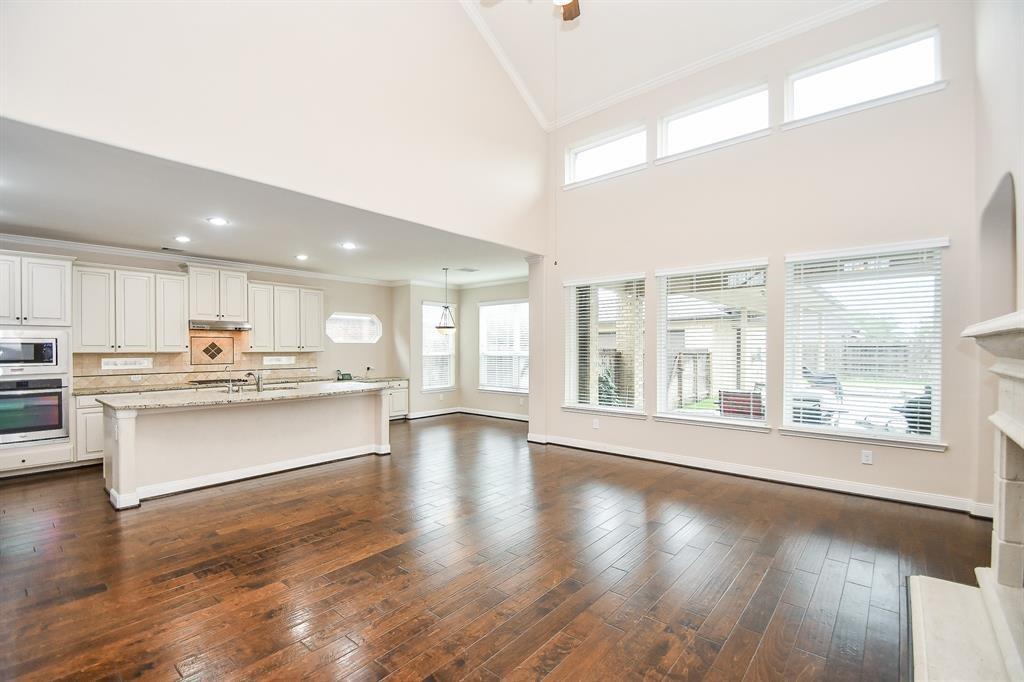 a large white kitchen with stainless steel appliances granite countertop a large window