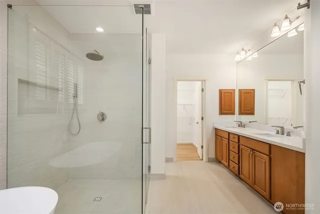a bathroom with a double vanity sink toilet mirror and shower