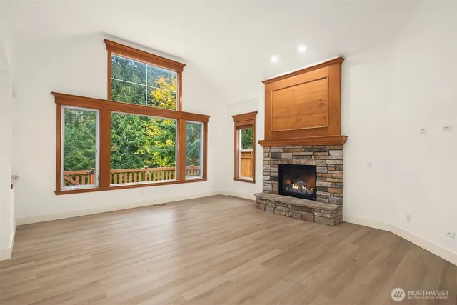 a view of an empty room with a window and fireplace