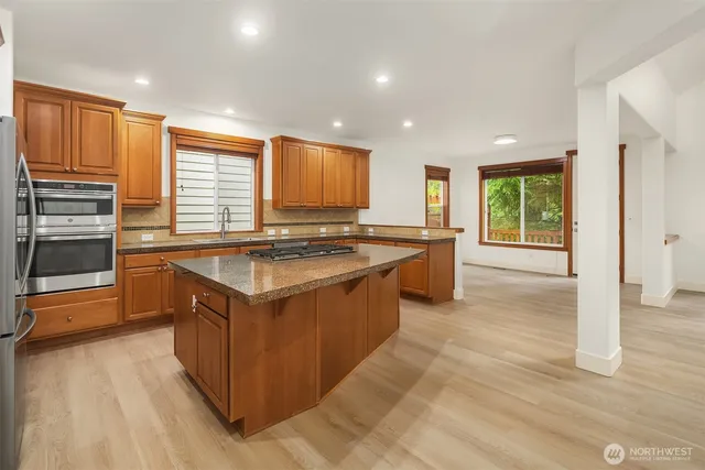 a kitchen with stainless steel appliances granite countertop a stove a sink and a refrigerator