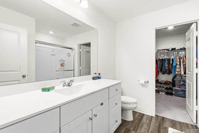 a bathroom with a sink a toilet and shower