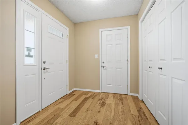a view of a hallway with wooden floor and entryway