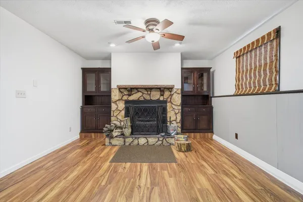 a view of empty room with wooden floor and window