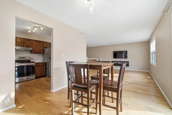a view of an empty room with a window and a kitchen