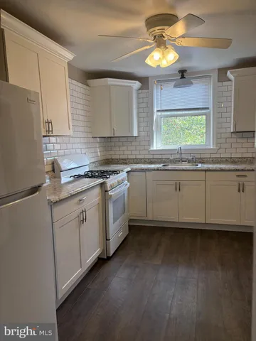 a kitchen with stainless steel appliances granite countertop a sink cabinets and a refrigerator