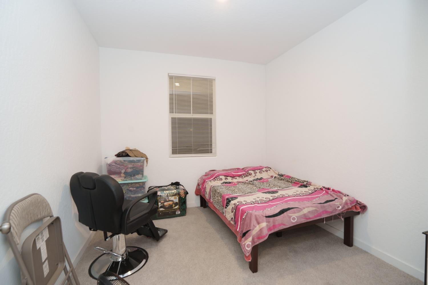 5769 West Austin Way Fresno, CA 93722 - Photo 13 of 32 a bedroom with a bed and a desk