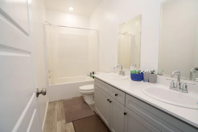 a bathroom with a granite countertop sink a toilet and shower