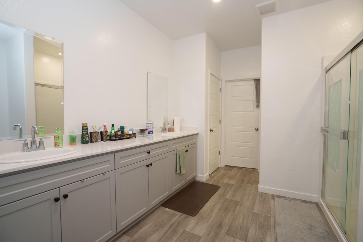 5769 West Austin Way Fresno, CA 93722 - Photo 18 of 32 a spacious bathroom with a double vanity sink and mirror