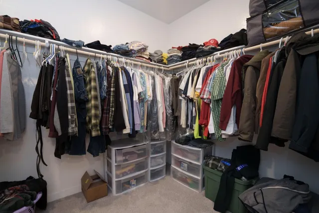 a view of walk in closet with clothes and shoes