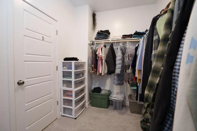 a view of walk in closet with clothes and shoes