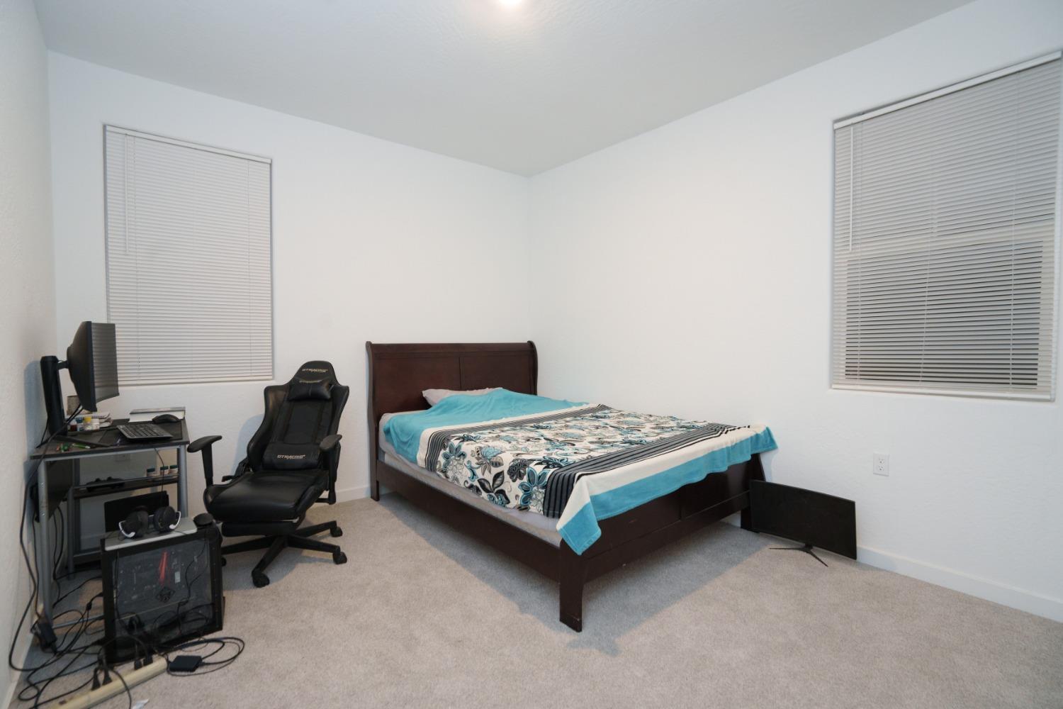 5769 West Austin Way Fresno, CA 93722 - Photo 22 of 32 a bedroom with a bed and a desk