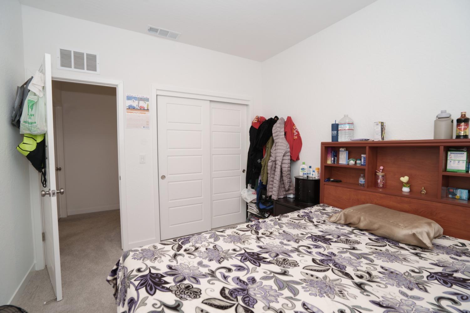 5769 West Austin Way Fresno, CA 93722 - Photo 25 of 32 a bed room with a bed and a mirror