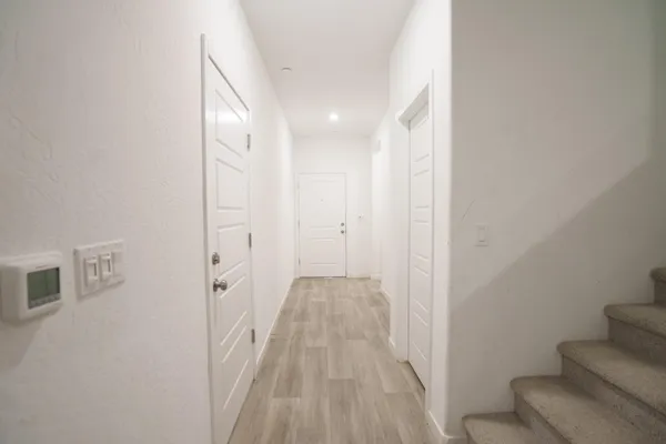 a view of a hallway with wooden floor and entryway
