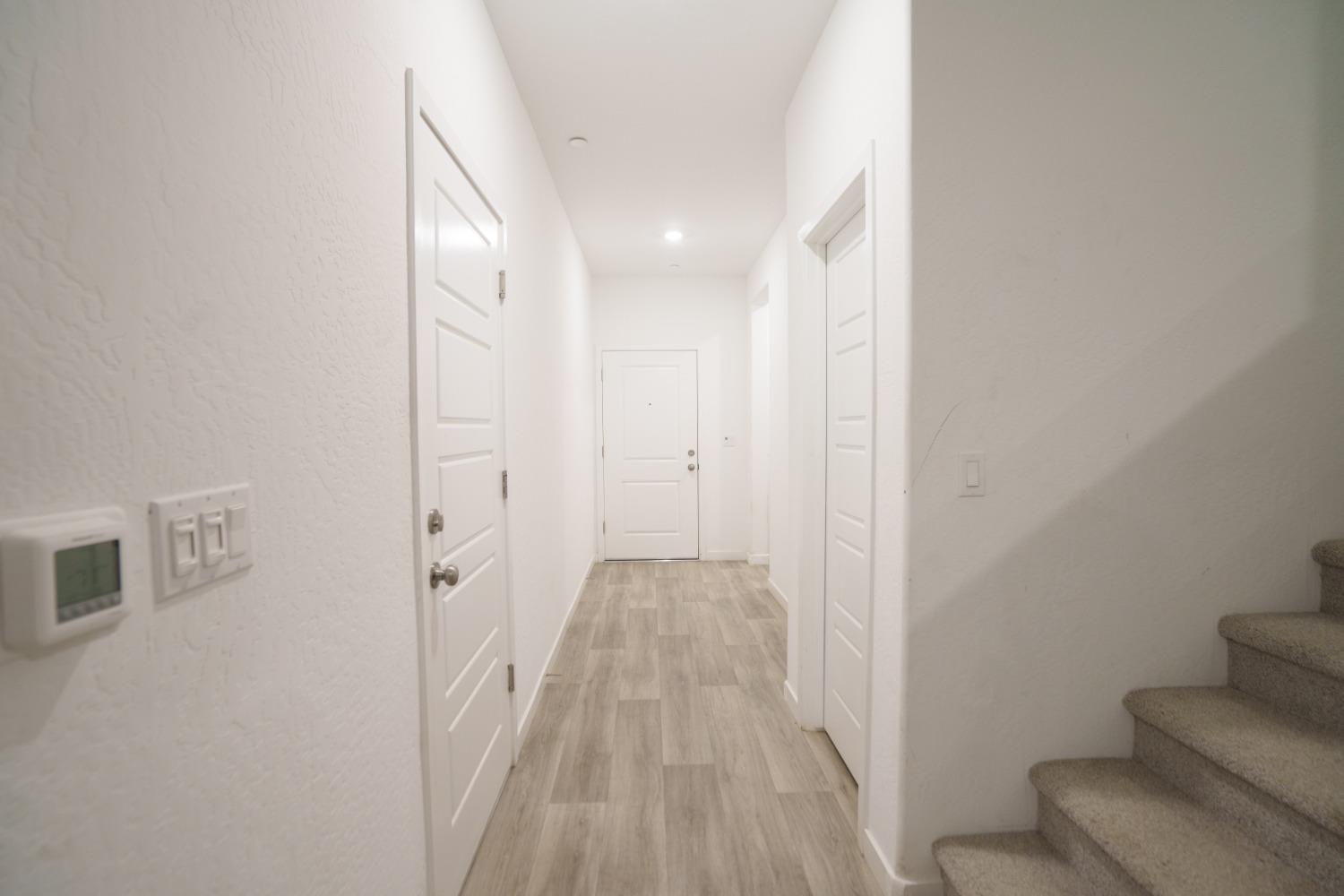 5769 West Austin Way Fresno, CA 93722 - Photo 3 of 32 a view of a hallway with wooden floor and entryway