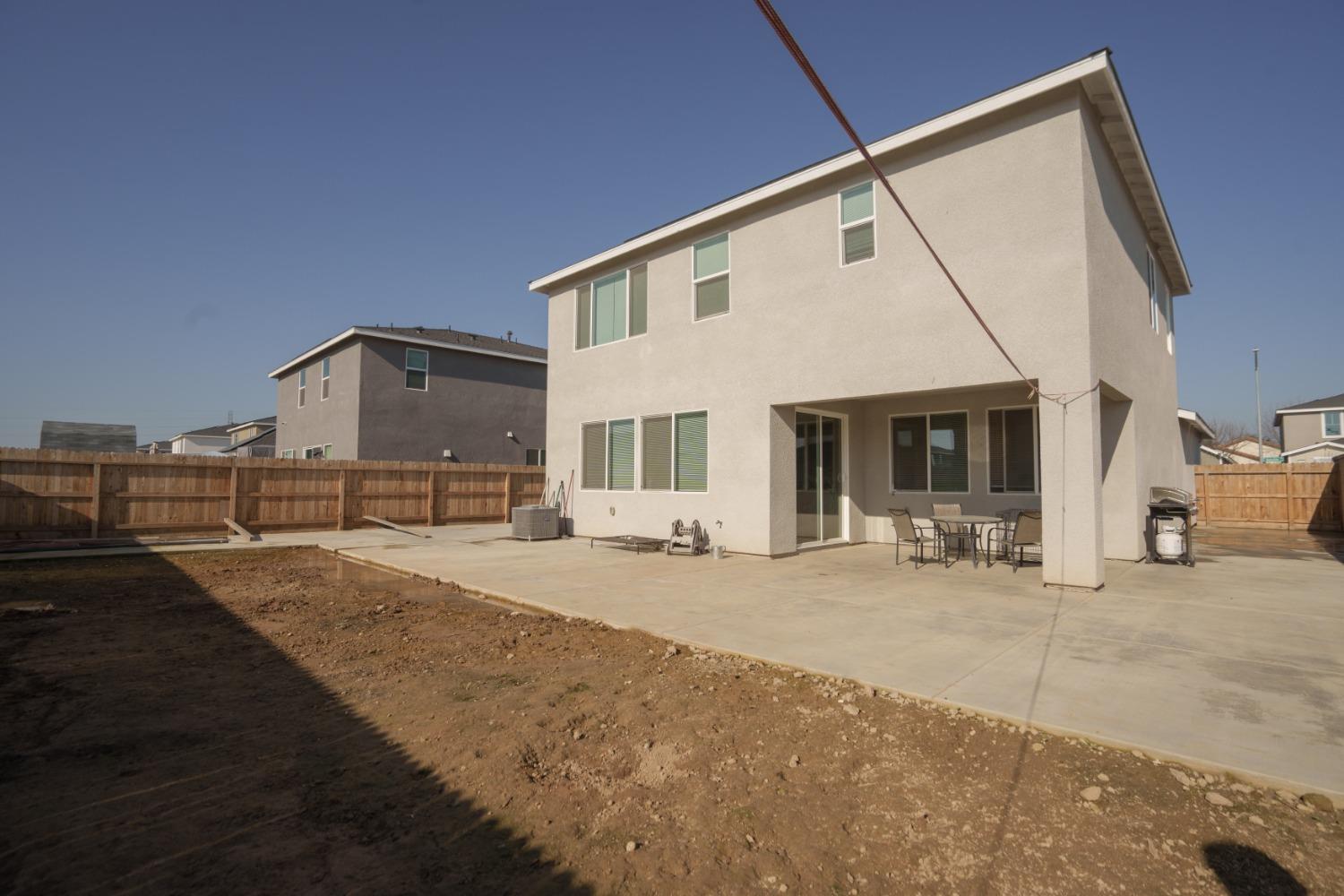 5769 West Austin Way Fresno, CA 93722 - Photo 32 of 32 a front view of a house with yard and seating space
