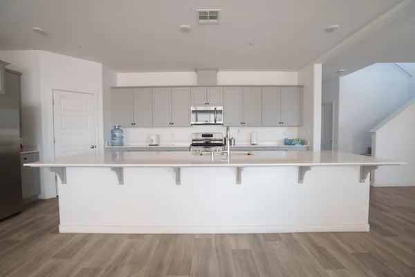 a white kitchen with wooden floor
