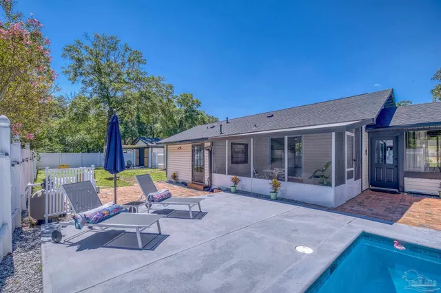 a view of a house with swimming pool and sitting area