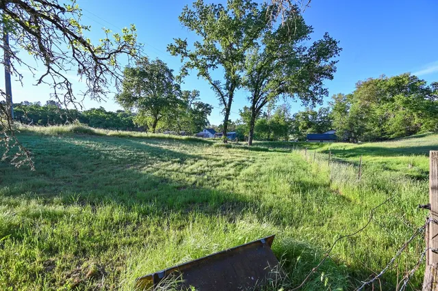 a large kitchen with stainless steel appliances a stove a sink dishwasher and a dining table with wooden floor